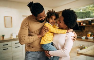 happy african american parents with daughter home
