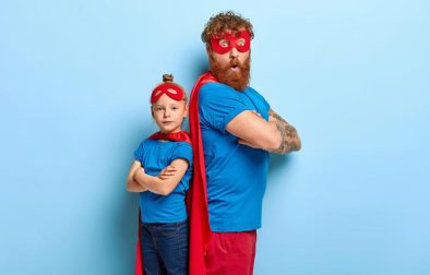 red haired father daughter play superhero game together stand backs have fun