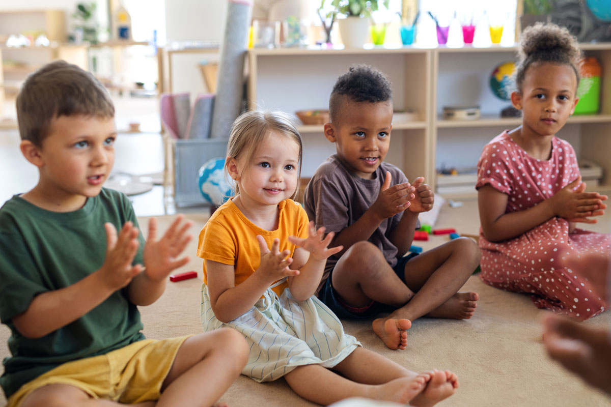 group-small-nursery-school-children-sitting-floor-indoors-classroom-clapping